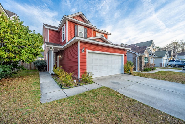 traditional-style home with a front lawn, fence, and driveway