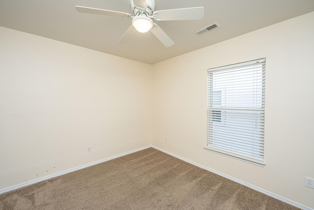 empty room with a ceiling fan, visible vents, carpet floors, and baseboards