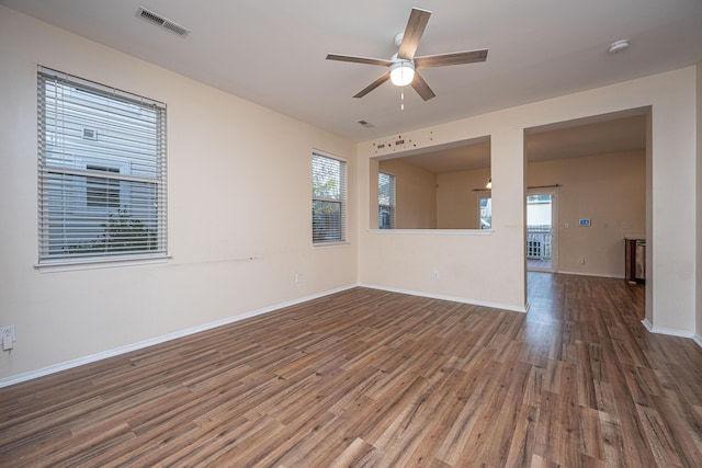 spare room featuring visible vents, baseboards, ceiling fan, and wood finished floors