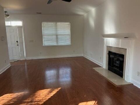 unfurnished living room featuring ceiling fan and dark hardwood / wood-style floors