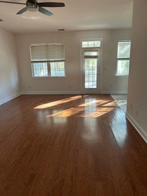 empty room with dark hardwood / wood-style floors and ceiling fan