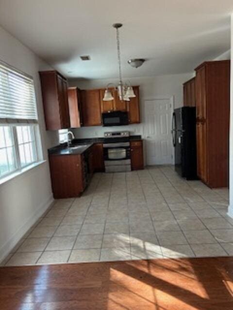 kitchen featuring sink, black appliances, light tile patterned floors, decorative light fixtures, and a chandelier