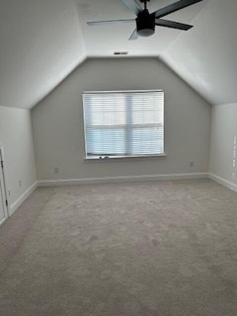 additional living space featuring ceiling fan, light colored carpet, and lofted ceiling