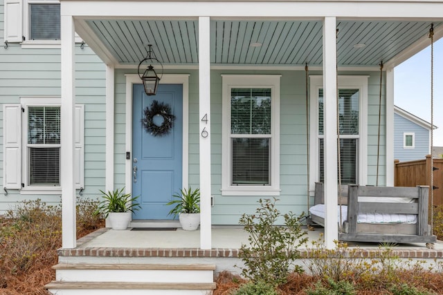 view of exterior entry featuring covered porch