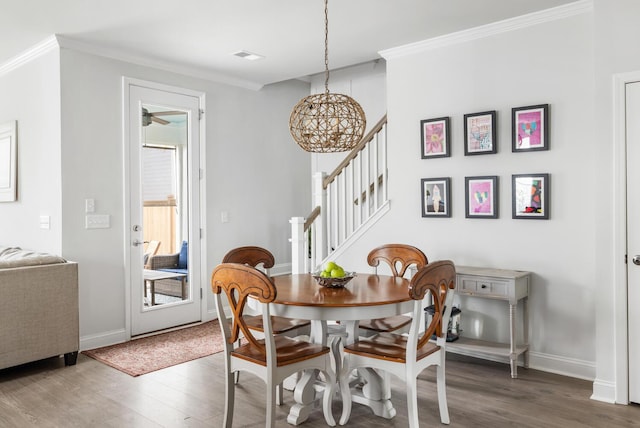 dining area with hardwood / wood-style flooring and crown molding