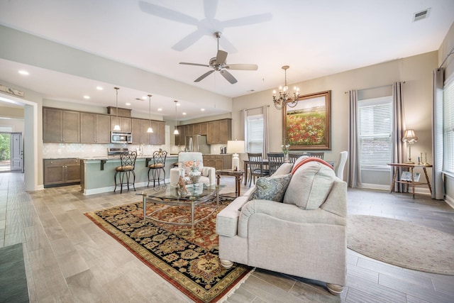 living room with recessed lighting, baseboards, visible vents, and ceiling fan with notable chandelier