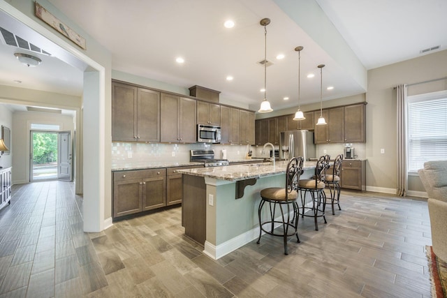 kitchen featuring stainless steel appliances, visible vents, a sink, and light wood-style flooring