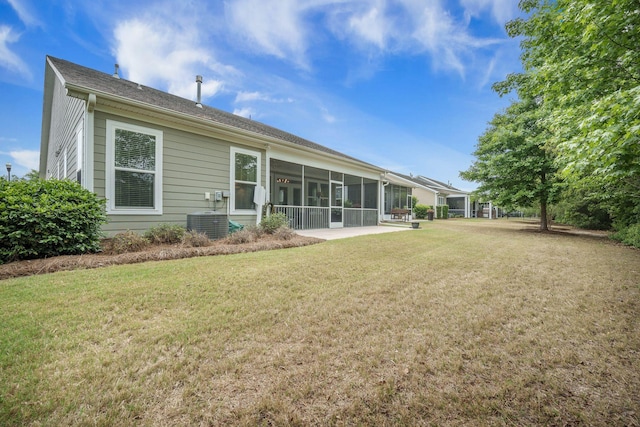 back of property with a lawn, central air condition unit, and a sunroom