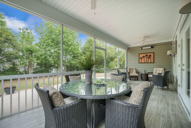 sunroom featuring a ceiling fan, an outdoor hangout area, and outdoor dining space
