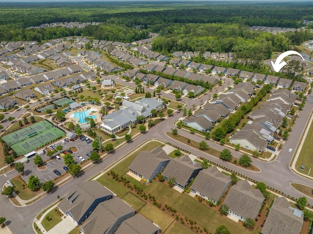 drone / aerial view featuring a residential view and a wooded view