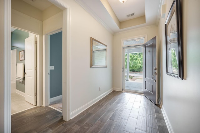 doorway to outside with baseboards, ornamental molding, dark wood-style floors, and visible vents