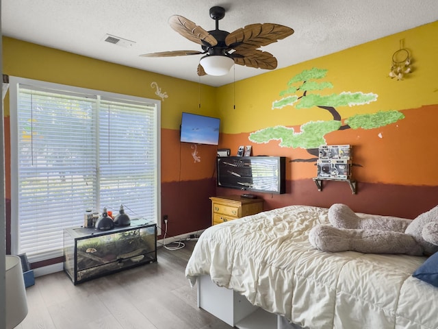 1317 Wild Olive Dr, Mount Pleasant, SC 29464 - bedroom with wood finished floors, a textured ceiling, baseboards, and a ceiling fan