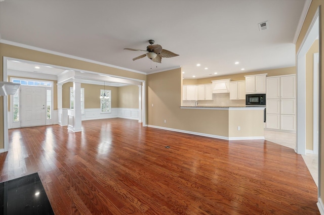 unfurnished living room with ornamental molding, light hardwood / wood-style floors, ceiling fan, and ornate columns