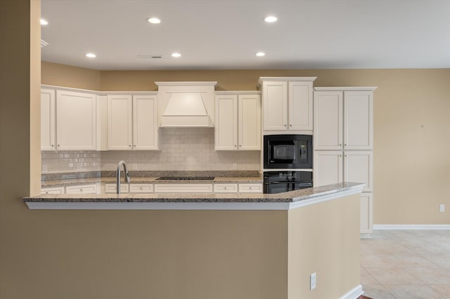 kitchen with white cabinetry, black appliances, decorative backsplash, custom exhaust hood, and dark stone counters