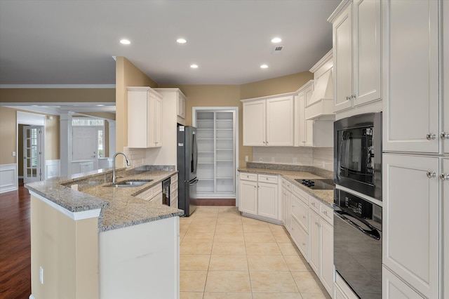 kitchen with white cabinetry, sink, and black appliances