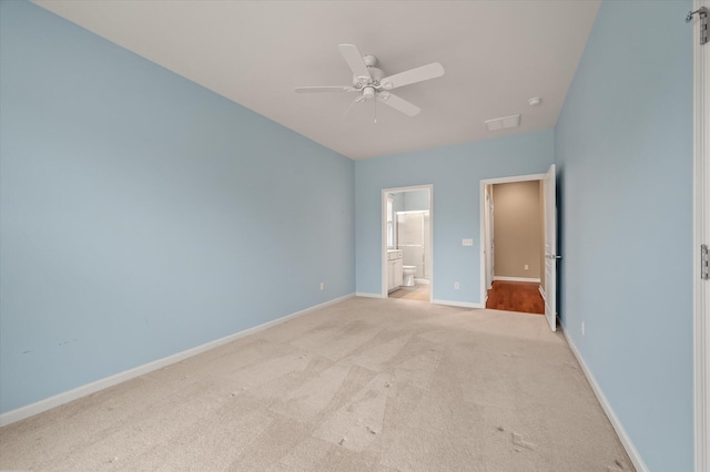 unfurnished bedroom featuring connected bathroom, light colored carpet, and ceiling fan