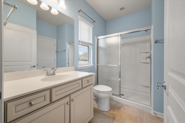 bathroom with tile patterned flooring, vanity, toilet, and a shower with shower door