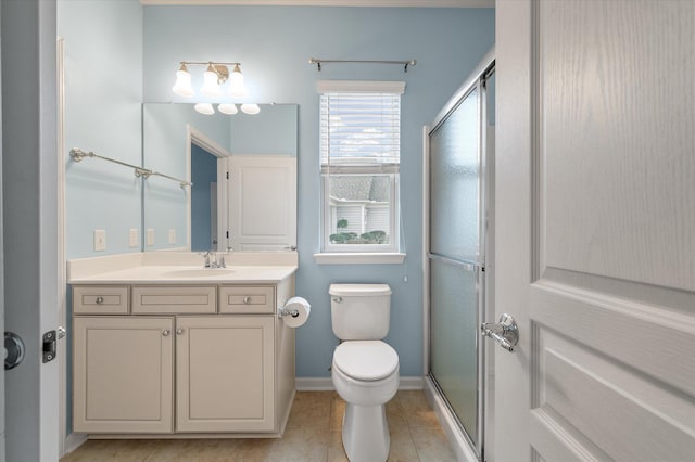 bathroom featuring tile patterned flooring, vanity, a shower with door, and toilet