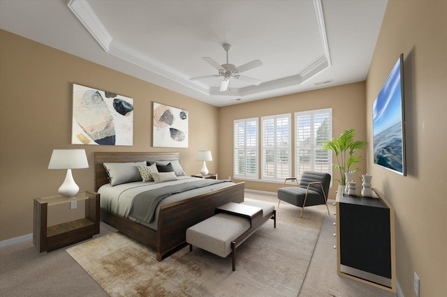 carpeted bedroom featuring a raised ceiling and ceiling fan