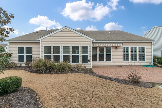 rear view of property with a yard and a patio