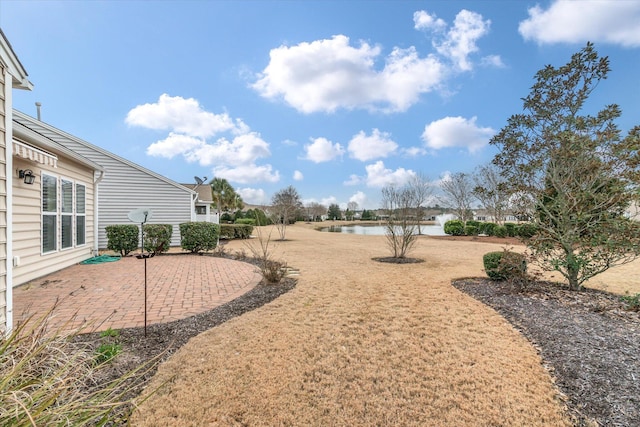 view of yard featuring a water view and a patio area