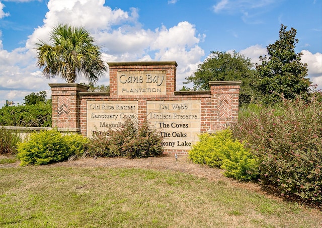 community / neighborhood sign featuring a lawn