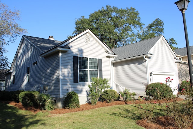 view of property exterior featuring a garage and a lawn