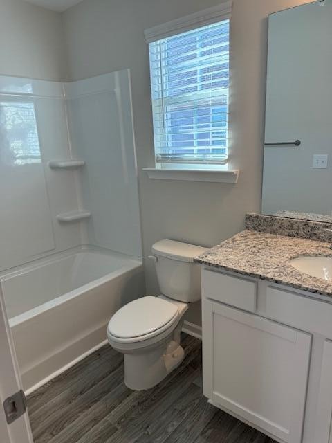 full bathroom featuring hardwood / wood-style floors, vanity, toilet, and shower / tub combination