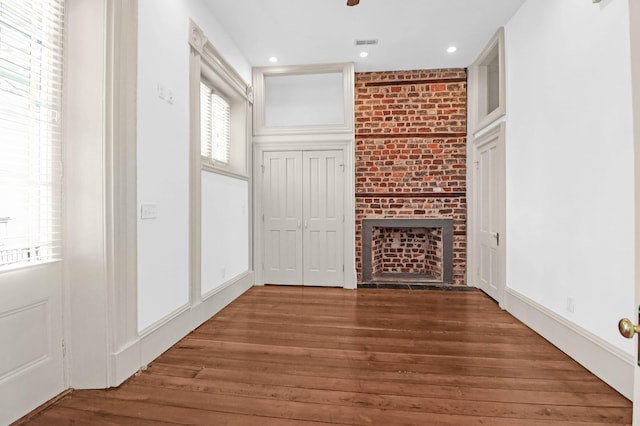 35 Society St Unit D, Charleston, SC 29401 - unfurnished living room featuring a brick fireplace, recessed lighting, wood finished floors, and visible vents