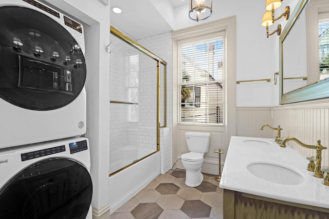 35 Society St Unit D, Charleston, SC 29401 - full bathroom with a sink, wainscoting, stacked washing maching and dryer, and toilet