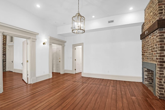 35 Society St Unit D, Charleston, SC 29401 - unfurnished living room with visible vents, wood-type flooring, a brick fireplace, and baseboards