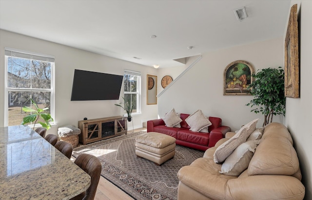 living room with visible vents, plenty of natural light, and wood finished floors