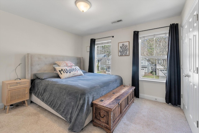 bedroom with visible vents, baseboards, and light colored carpet