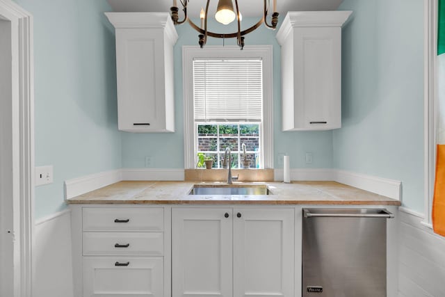 kitchen with sink, an inviting chandelier, white cabinetry, and stainless steel dishwasher