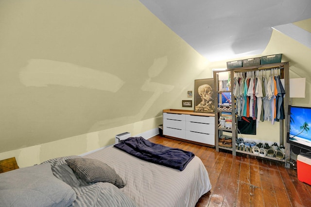 bedroom with vaulted ceiling and hardwood / wood-style flooring