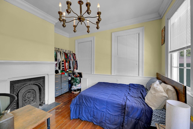 bedroom featuring dark wood-type flooring, crown molding, and a notable chandelier