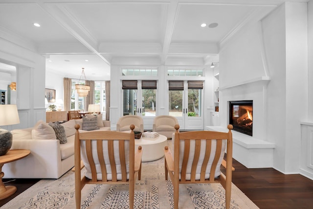 living room featuring crown molding, a healthy amount of sunlight, built in features, and beam ceiling