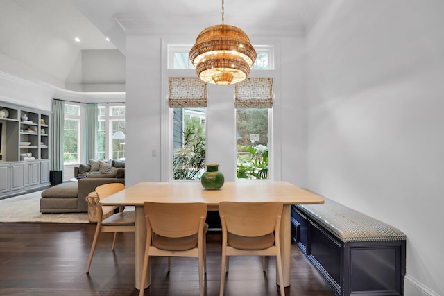 dining area with crown molding, dark hardwood / wood-style flooring, and a chandelier