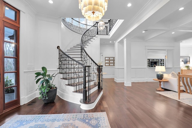 entryway with ornate columns, crown molding, dark hardwood / wood-style floors, and a wealth of natural light