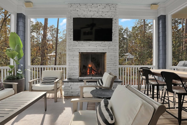 sunroom / solarium with a wealth of natural light and an outdoor stone fireplace