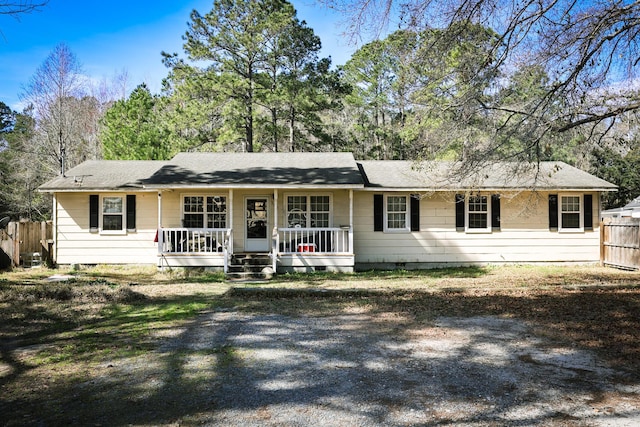 single story home with covered porch, fence, and crawl space