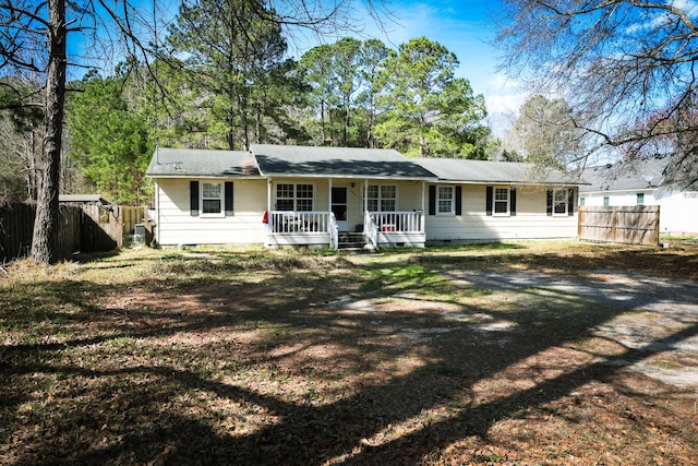 back of property with crawl space, fence, and a porch