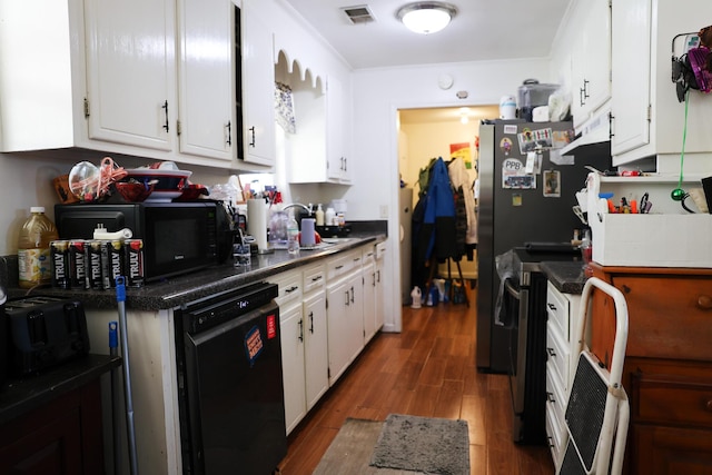 kitchen with dark countertops, visible vents, white cabinetry, wood finished floors, and black appliances