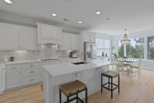 1216 Rivers Reach Dr, Charleston, SC 29492 - kitchen featuring stainless steel fridge, a sink, black electric cooktop, tasteful backsplash, and light wood-style floors
