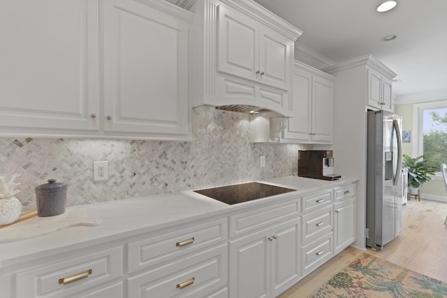 1216 Rivers Reach Dr, Charleston, SC 29492 - kitchen featuring stainless steel fridge, black electric cooktop, white cabinetry, light wood-style flooring, and light stone countertops