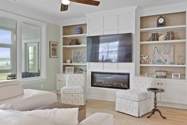 1216 Rivers Reach Dr, Charleston, SC 29492 - living room with crown molding, light wood-type flooring, a large fireplace, a ceiling fan, and built in shelves