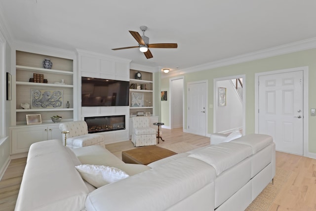 1216 Rivers Reach Dr, Charleston, SC 29492 - living room featuring ceiling fan, light wood finished floors, ornamental molding, a glass covered fireplace, and built in shelves