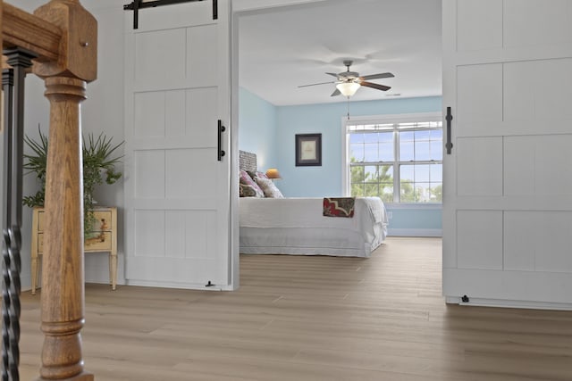 1216 Rivers Reach Dr, Charleston, SC 29492 - bedroom with light wood-style floors, a barn door, baseboards, and ceiling fan
