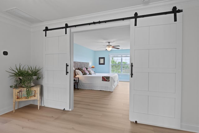 1216 Rivers Reach Dr, Charleston, SC 29492 - bedroom featuring a barn door, light wood-type flooring, ornamental molding, baseboards, and ceiling fan