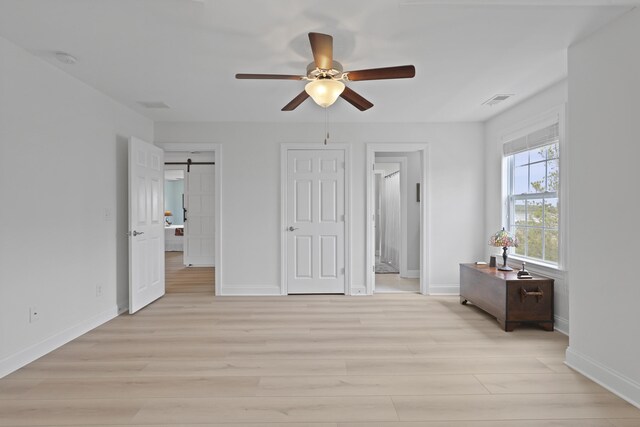 1216 Rivers Reach Dr, Charleston, SC 29492 - bedroom with light wood-style flooring, baseboards, a barn door, and a ceiling fan